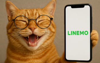 満面の笑みを浮かべたメガネの茶トラ猫が、画面に「LINEMO」と表示されたスマートフォンを自慢げに掲げている画像。