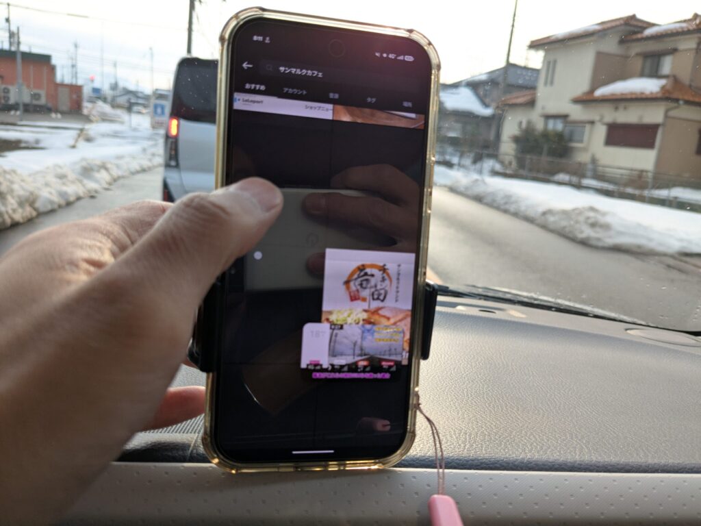 車内での実用テスト（YouTube） 車内に設置したスマホでYouTubeを視聴している様子。動画再生は行われているものの、周囲のサムネイル画像の読み込みが遅れている状態を示し、実際の通信環境における挙動を記録している。